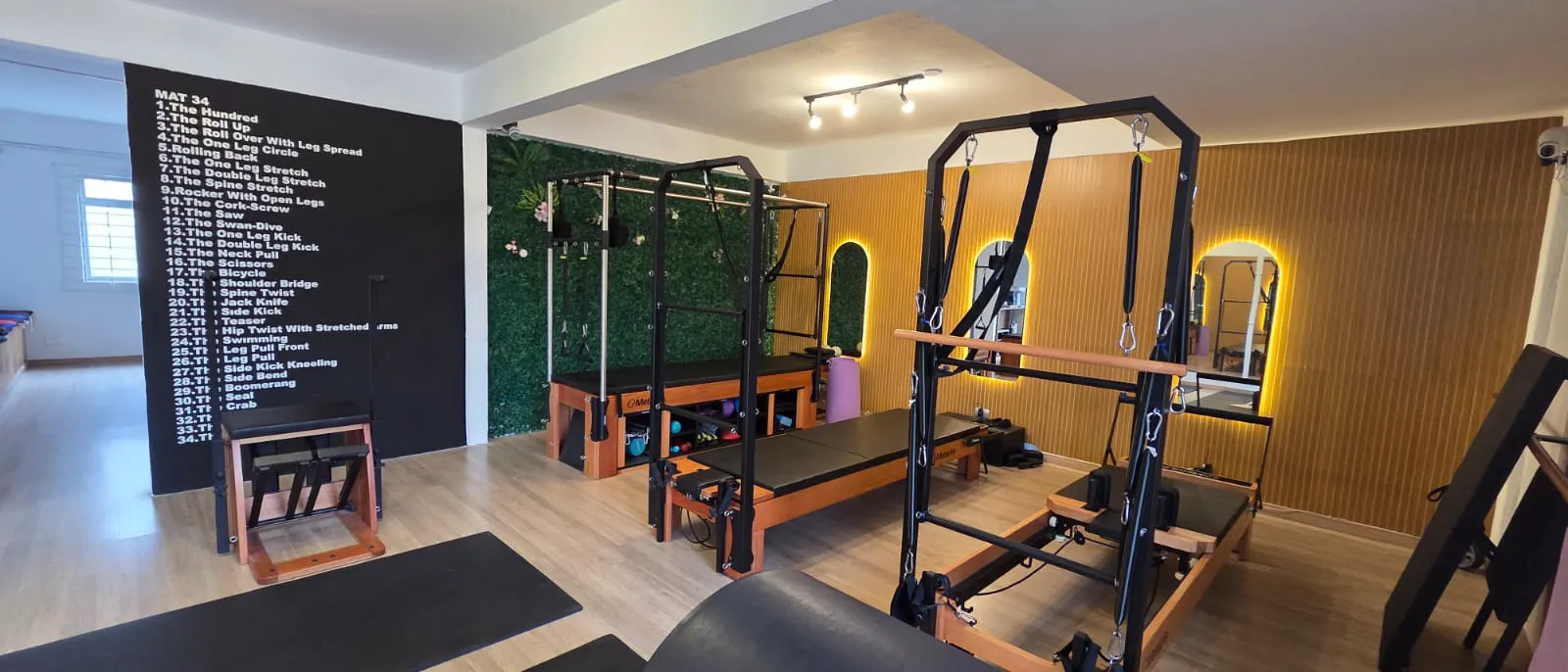 Sala de aparelhos de Pilates do Studio Aline Diório com reformers, cadillac e espelhos